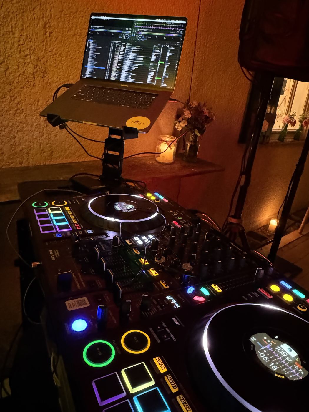 DJ-Laptop auf Stativ bei Kerzenlicht am Abend