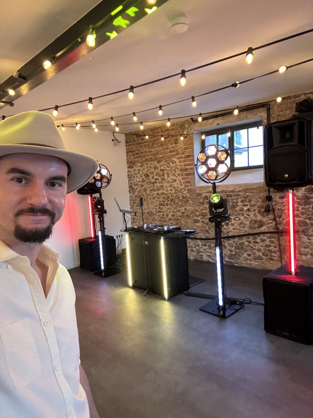 DJ-Pult mit cremefarbenem Hut in elegantem Saal mit Kronleuchter