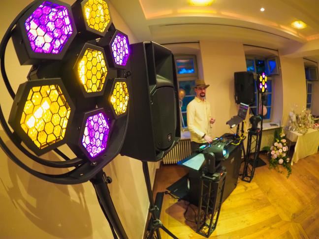 Paul am DJ-Pult im bunten Bühnenlicht, Fisheye-Perspektive