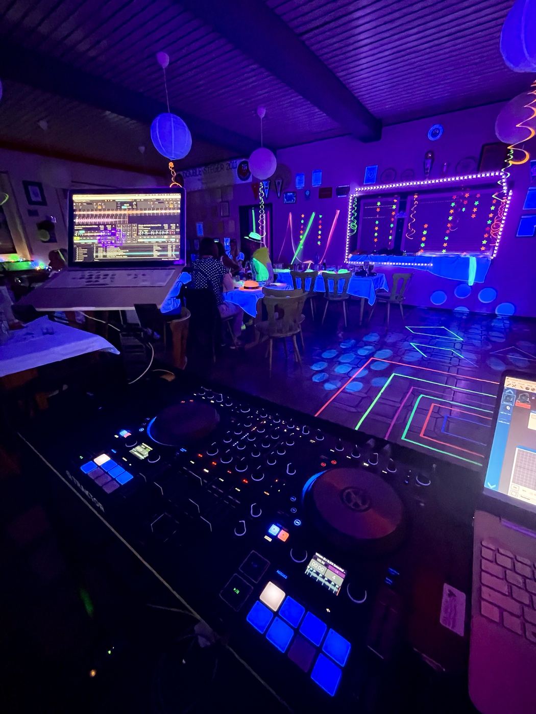 DJ-Pult bei Schwarzlicht-Party mit Neon-Deko